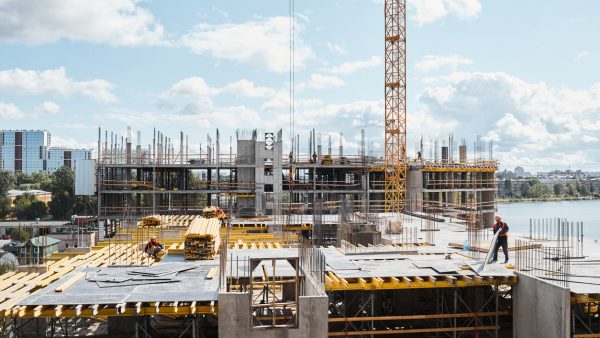 Wide angle view at construction site with unfinished residential buildings against blue sky, copy space